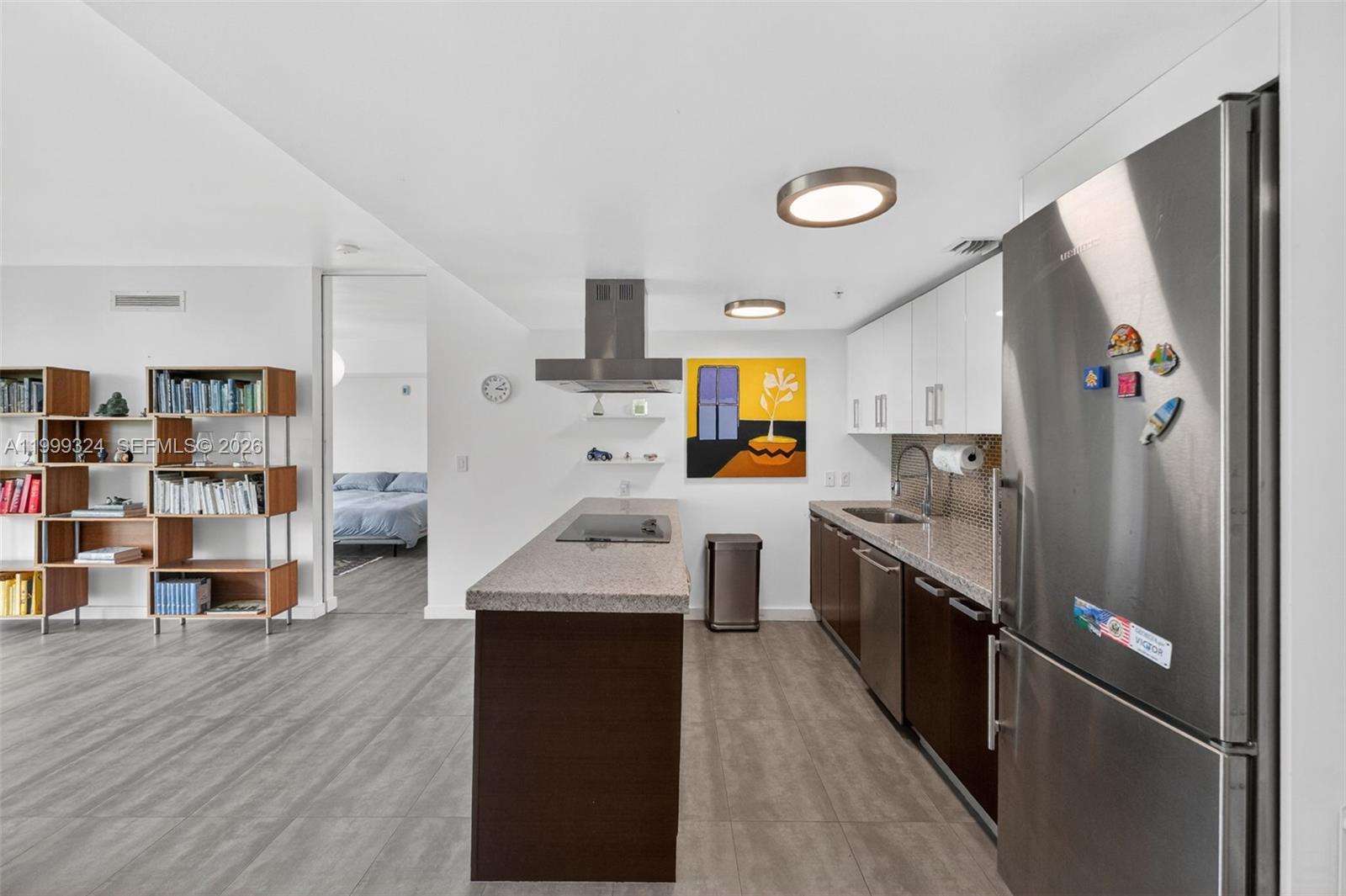 A modern kitchen features dark wood cabinetry, granite countertops, stainless steel appliances, and an island — 720 NE 62nd St # 404, Miami FL 33138, MIAMI, FL
