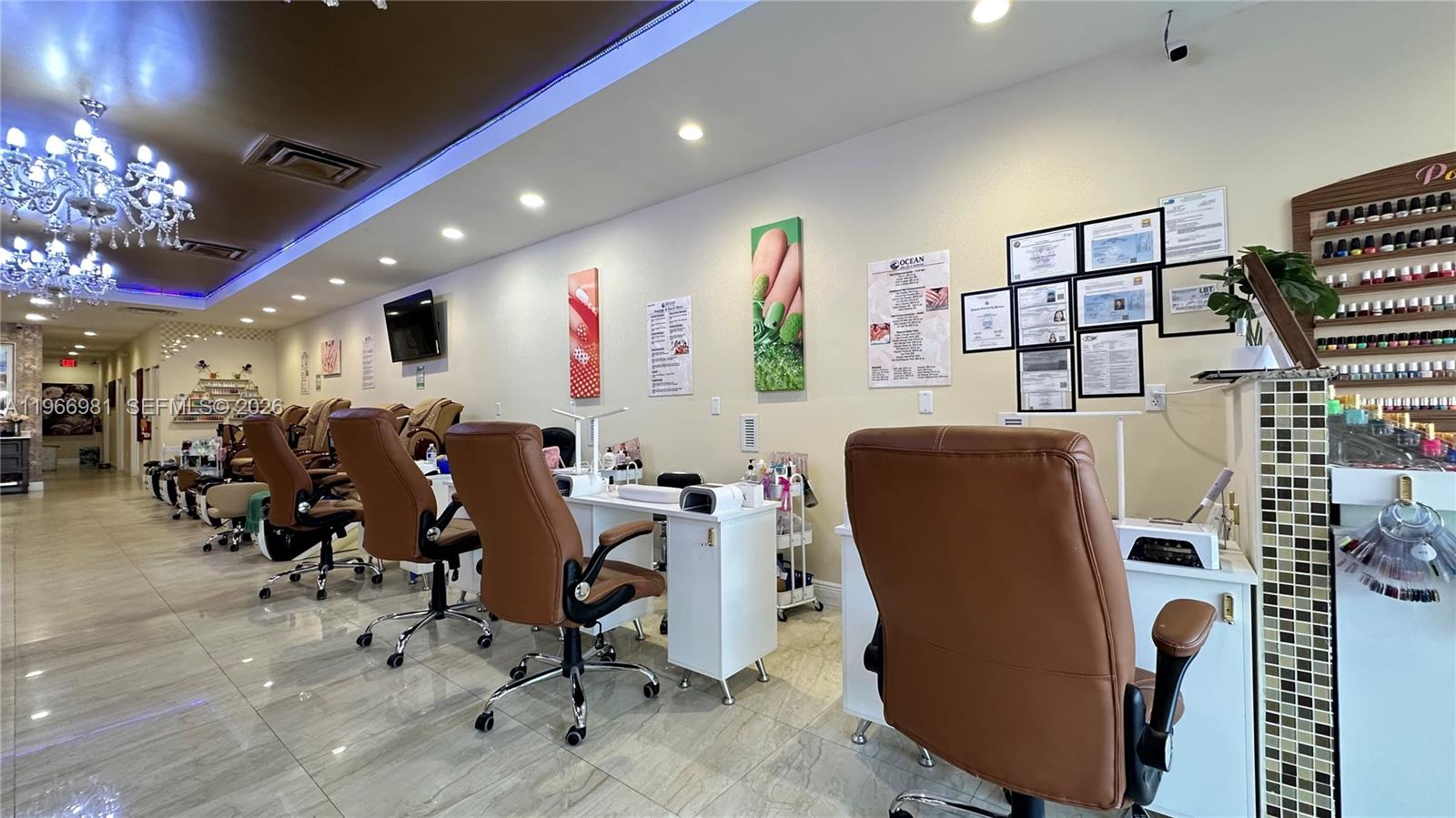 A nail salon features rows of brown leather chairs, white manicure stations, and wall-mounted decor — SW 40 St, Miami FL 33165, MIAMI, FL