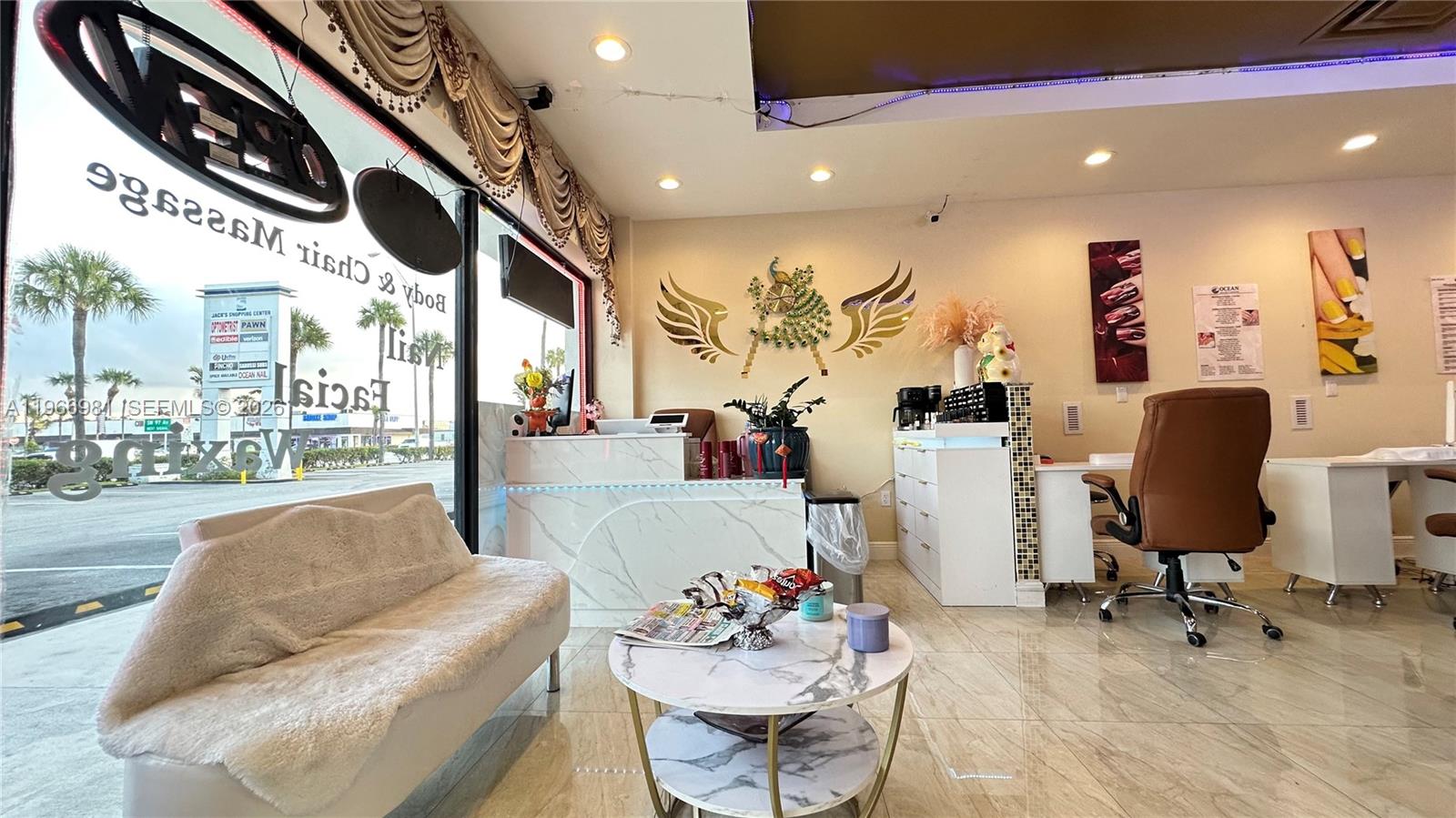 A nail salon interior features a white marble reception desk, waiting area, and manicure stations — SW 40 St, Miami FL 33165, MIAMI, FL