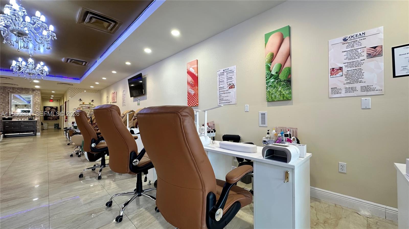 A nail salon features rows of brown leather chairs, white manicure tables, and decorative wall art — SW 40 St, Miami FL 33165, MIAMI, FL