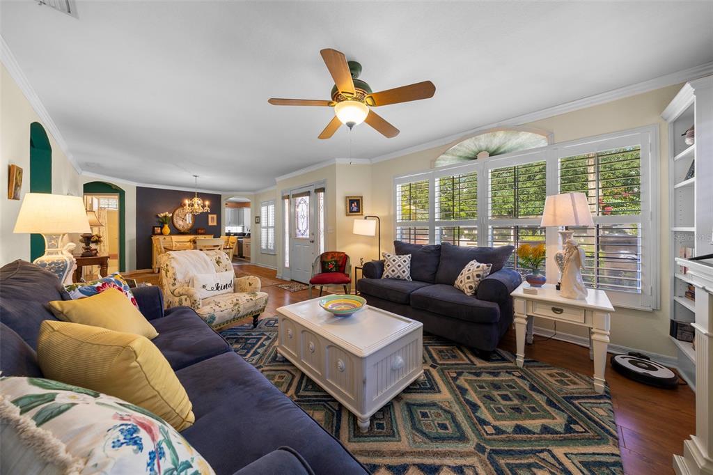 A living room features a blue sofa, a white coffee table, and a patterned rug — 7240 SW 115TH PLACE, OCALA, FL