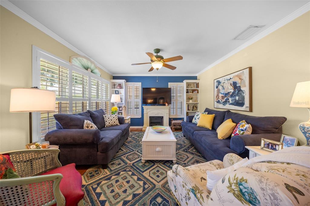 A living room features two navy sofas, a white coffee table, and a fireplace — 7240 SW 115TH PLACE, OCALA, FL