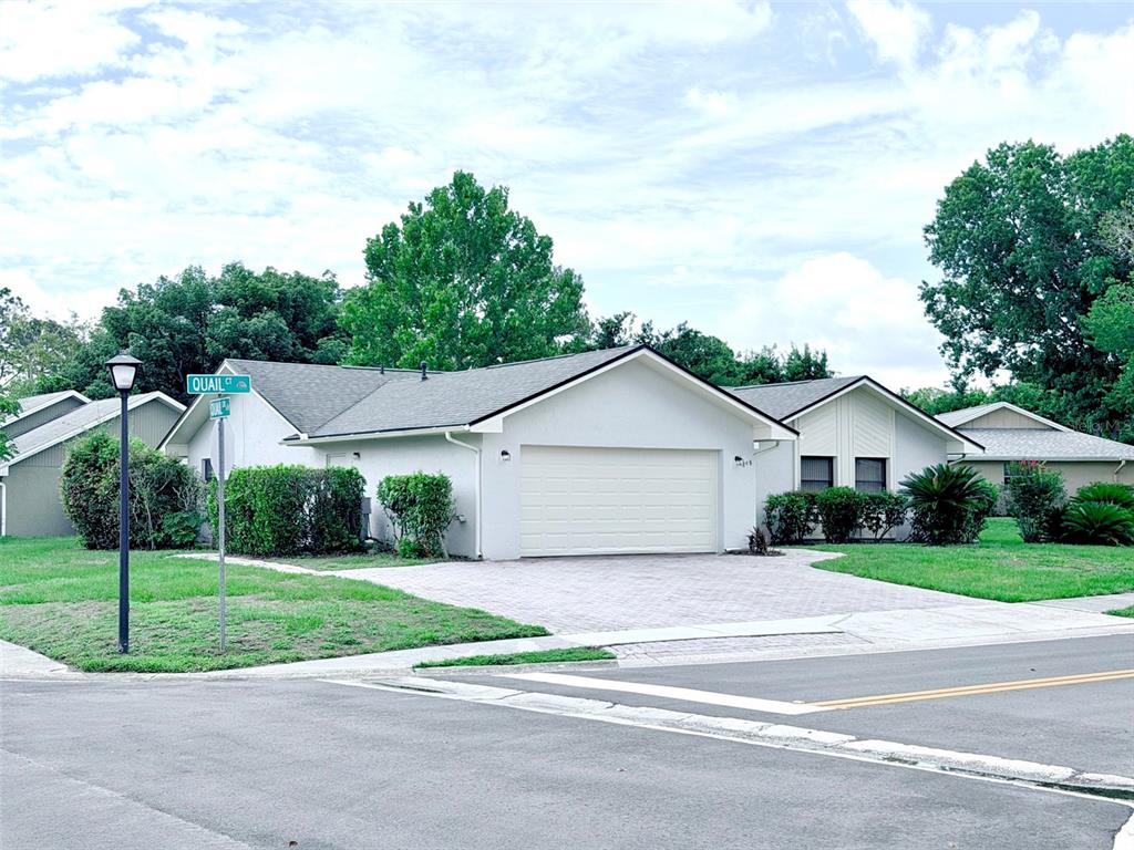A single-story house with a white exterior, a two-car garage, and a paved driveway — 298 QUAIL COURT, CASSELBERRY, FL