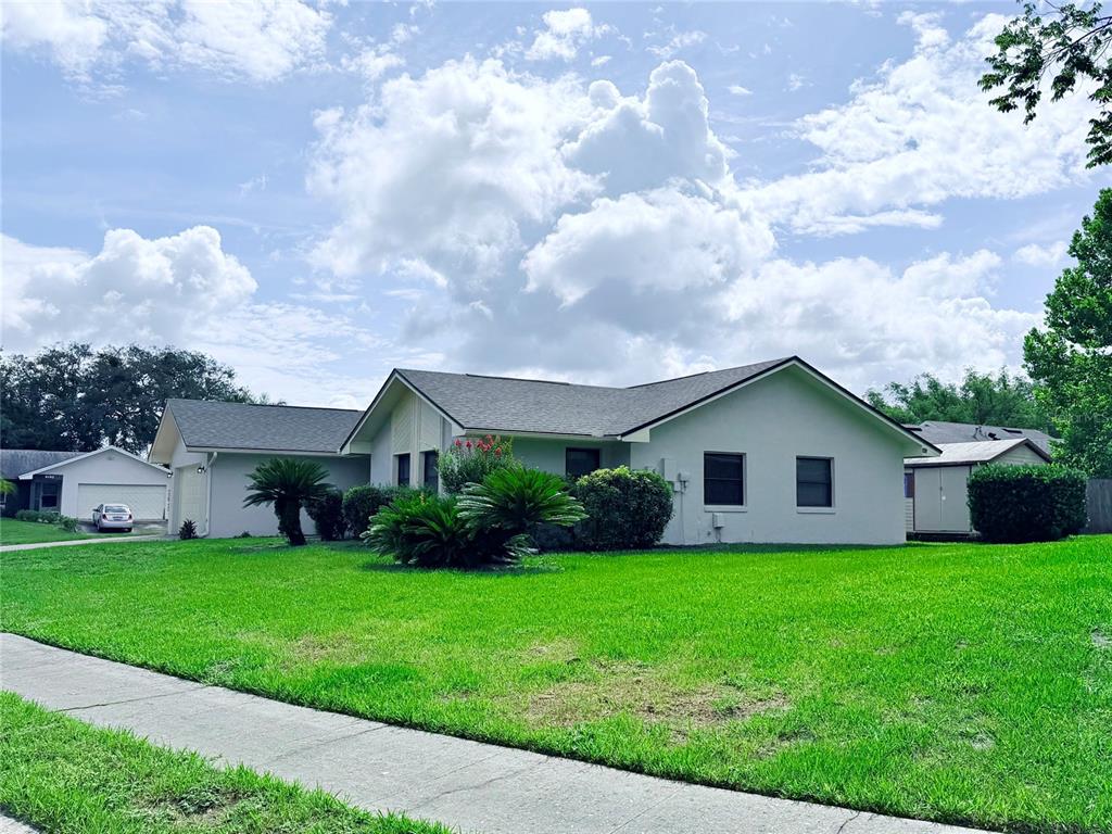 A single-story house with a light-colored exterior, a gray shingled roof, and a large lawn — 298 QUAIL COURT, CASSELBERRY, FL