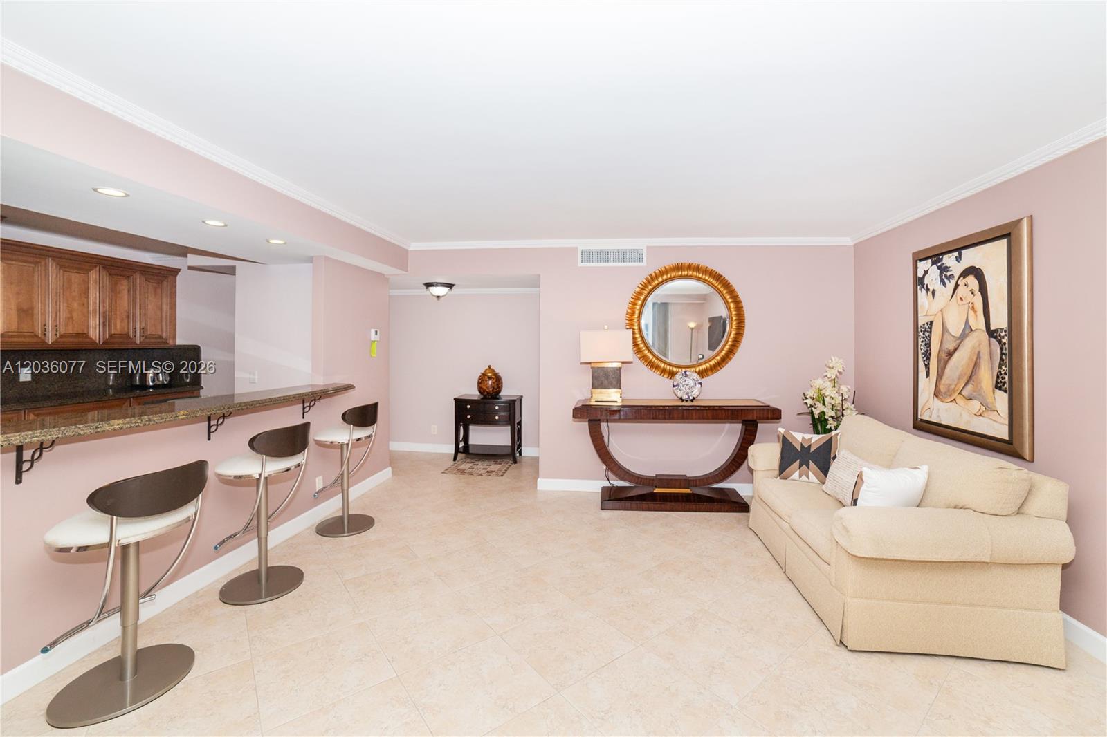 A living area with a breakfast bar, beige sofa, console table, and light pink walls — 1904 S Ocean Dr # 604, Hallandale Beach FL 33009, HALLANDALE BEACH, FL