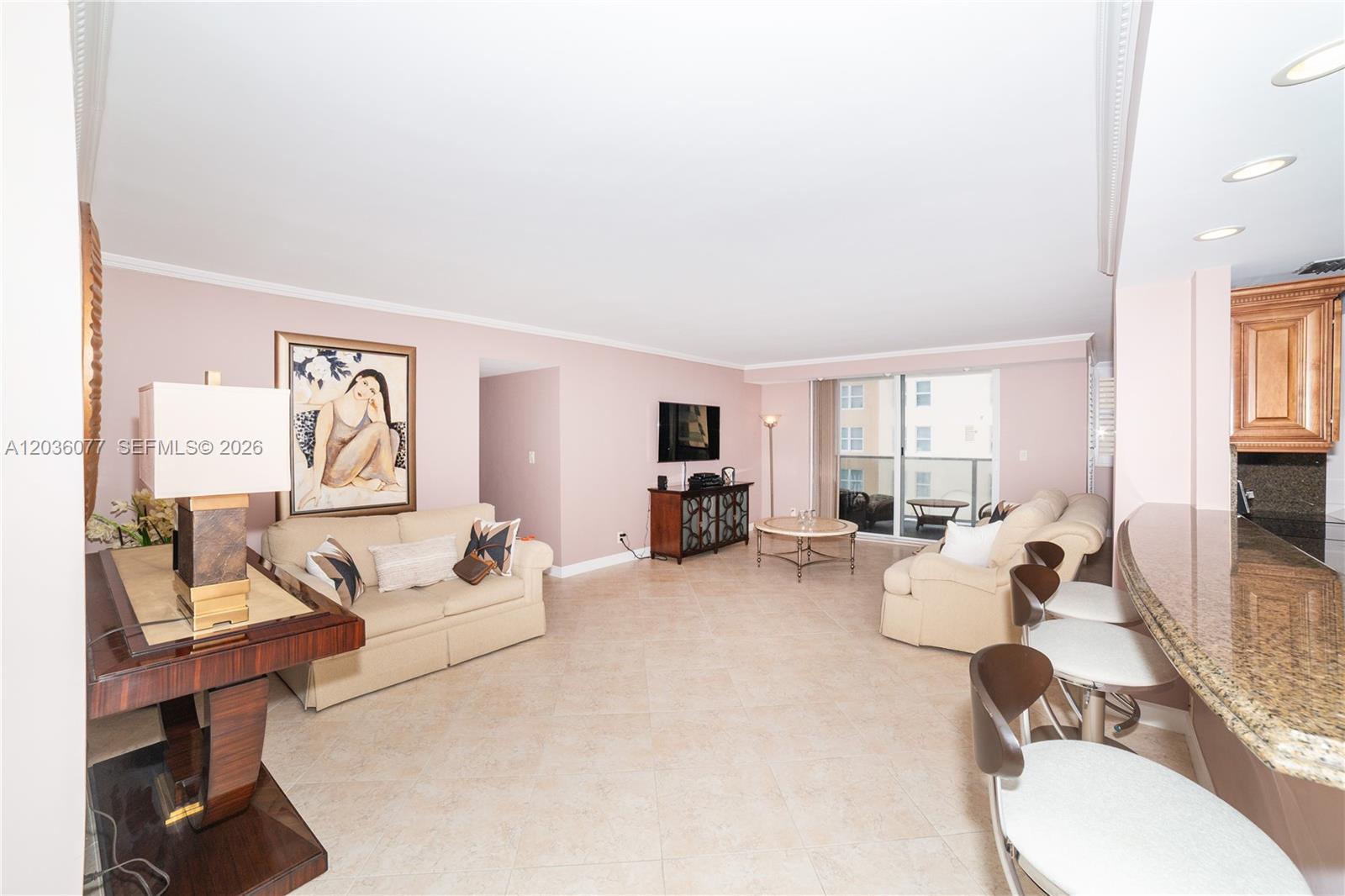 A living room with beige sofas, a breakfast bar, and a balcony view — 1904 S Ocean Dr # 604, Hallandale Beach FL 33009, HALLANDALE BEACH, FL