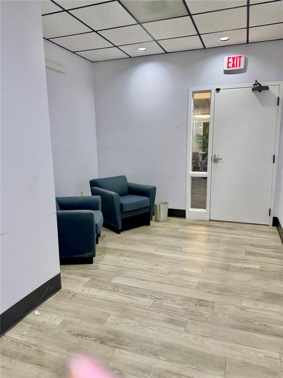 Two blue armchairs sit on a light wood-look floor in a room with an exit door — 6801 US HIGHWAY 27 N, SEBRING, FL