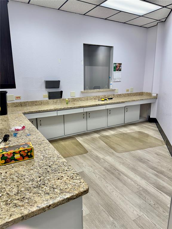 A commercial office space features granite countertops, white cabinetry, and light wood-look flooring — 6801 US HIGHWAY 27 N, SEBRING, FL