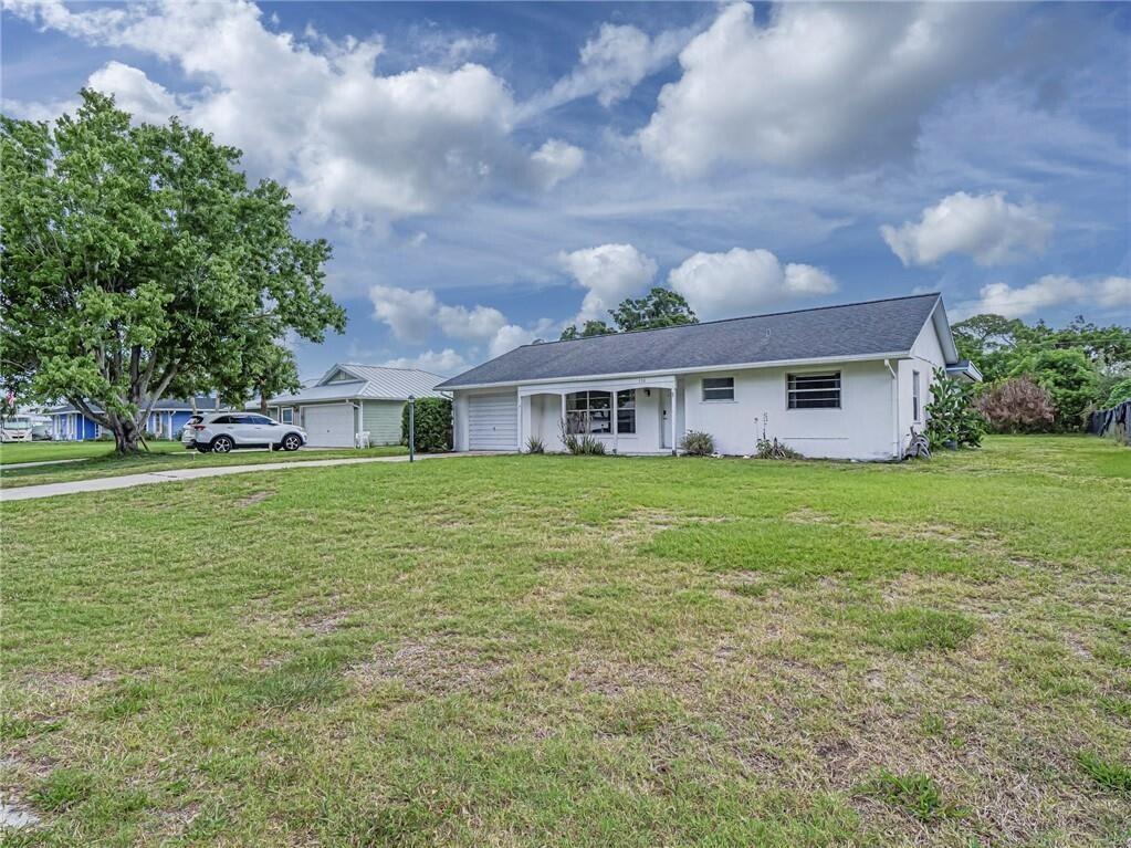 A single-story white house with a garage and a large front lawn under a sky — 136 16th Avenue, Vero Beach FL 32962, VERO BEACH, FL