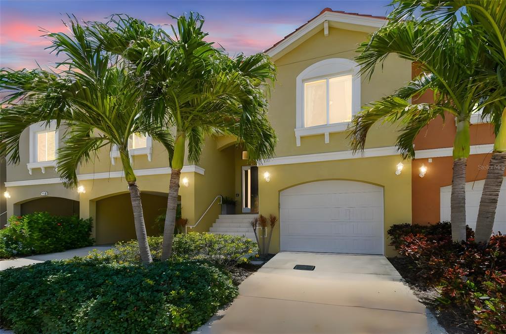 A two-story yellow house with a garage, palm trees, and a concrete driveway — 17 FRANKLIN COURT S UNIT C, ST PETERSBURG, FL