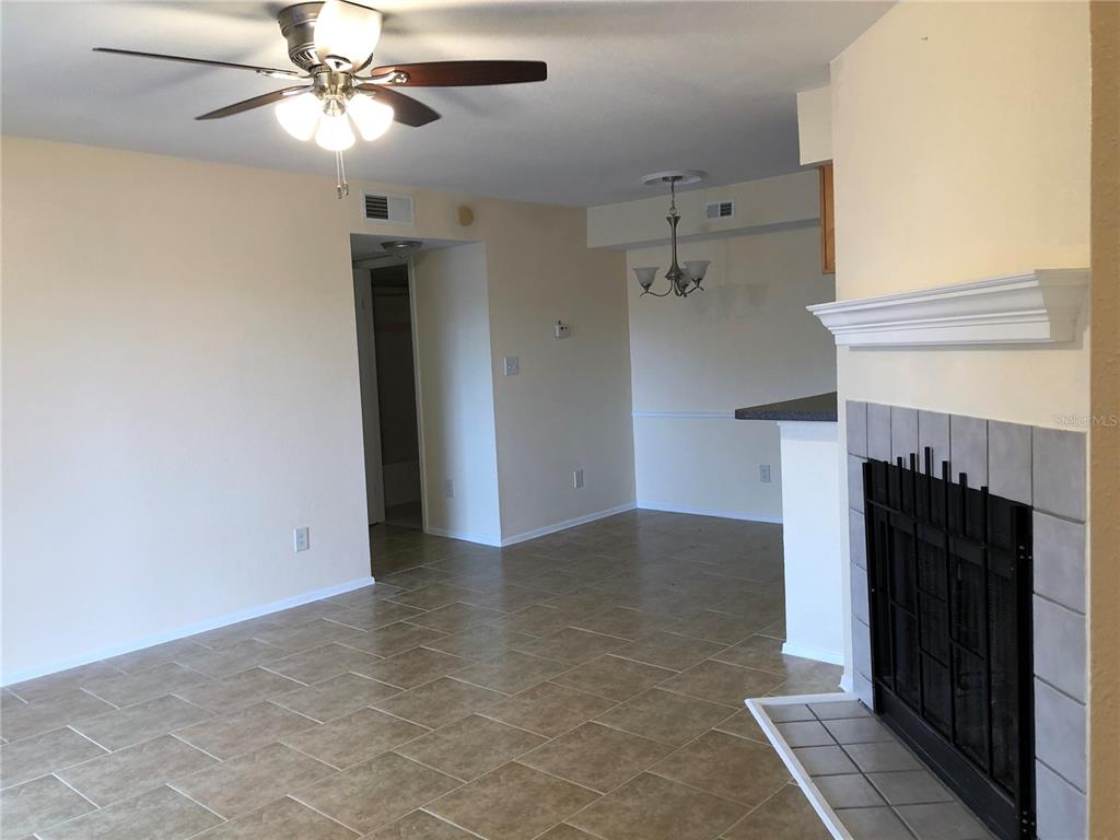 A living room with tile flooring, a ceiling fan, and a fireplace with a mantel — 9100 DR MARTIN LUTHER KING JR STREET N UNIT 202, ST PETERSBURG, FL