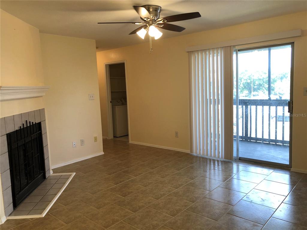 A living room features tile flooring, a fireplace, a ceiling fan, and a sliding glass door — 9100 DR MARTIN LUTHER KING JR STREET N UNIT 202, ST PETERSBURG, FL