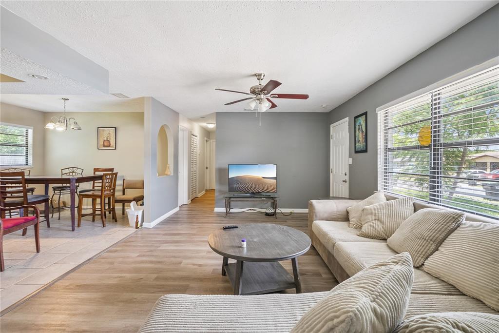 A living room with wood-look flooring, a ceiling fan, and a dining area nearby — 1691 LUCY TERRY AVENUE, APOPKA, FL