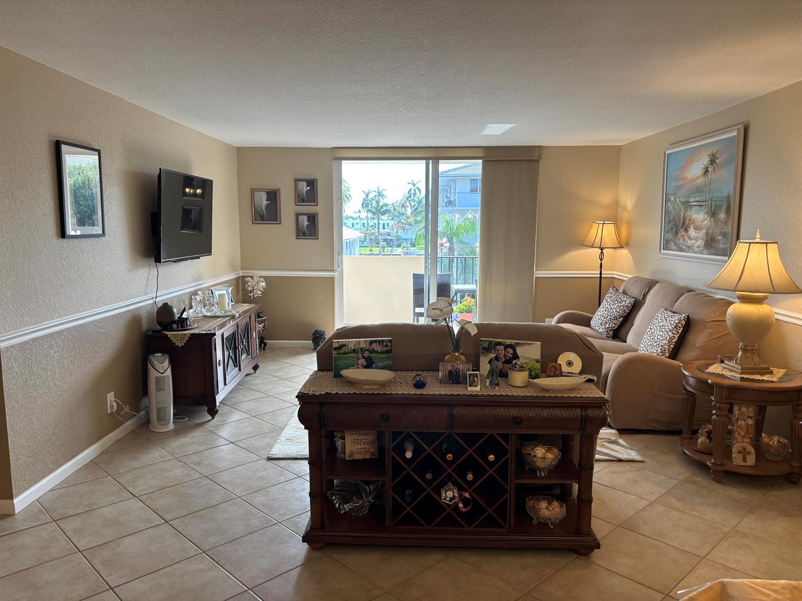 A living room features tile floors, a sofa, a wine rack console, and a balcony view — 1000 Spanish River Road # 3c, Boca Raton FL 33432, BOCA RATON, FL