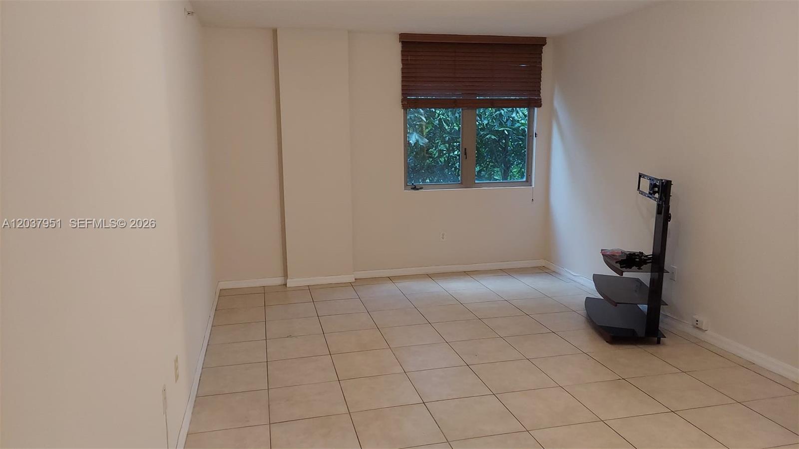 A laundry closet with a stacked washer and dryer is located at the end of a hallway — 2630 SW 28th St # 14, Miami FL 33133, MIAMI, FL