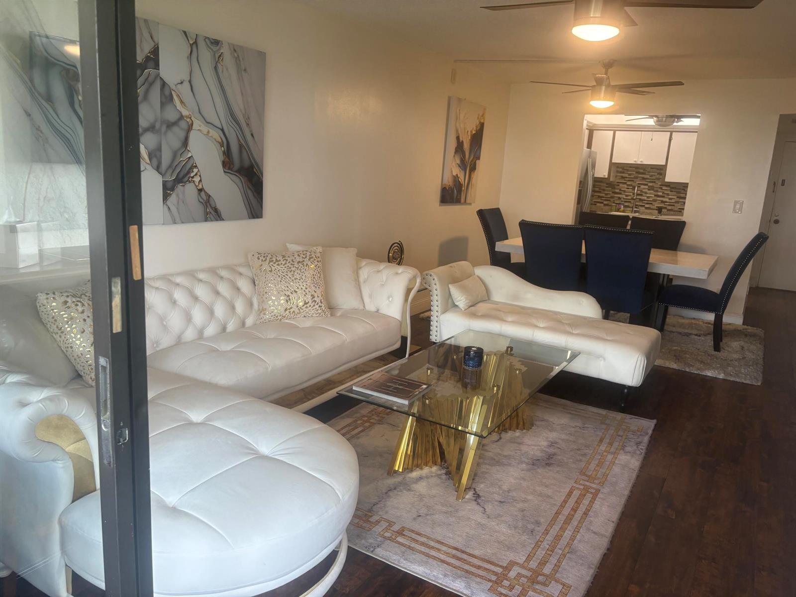 A living room features a white tufted sectional, a chaise lounge, and a glass coffee table — 9355 SW 8th Street # 225, Boca Raton FL 33428, BOCA RATON, FL