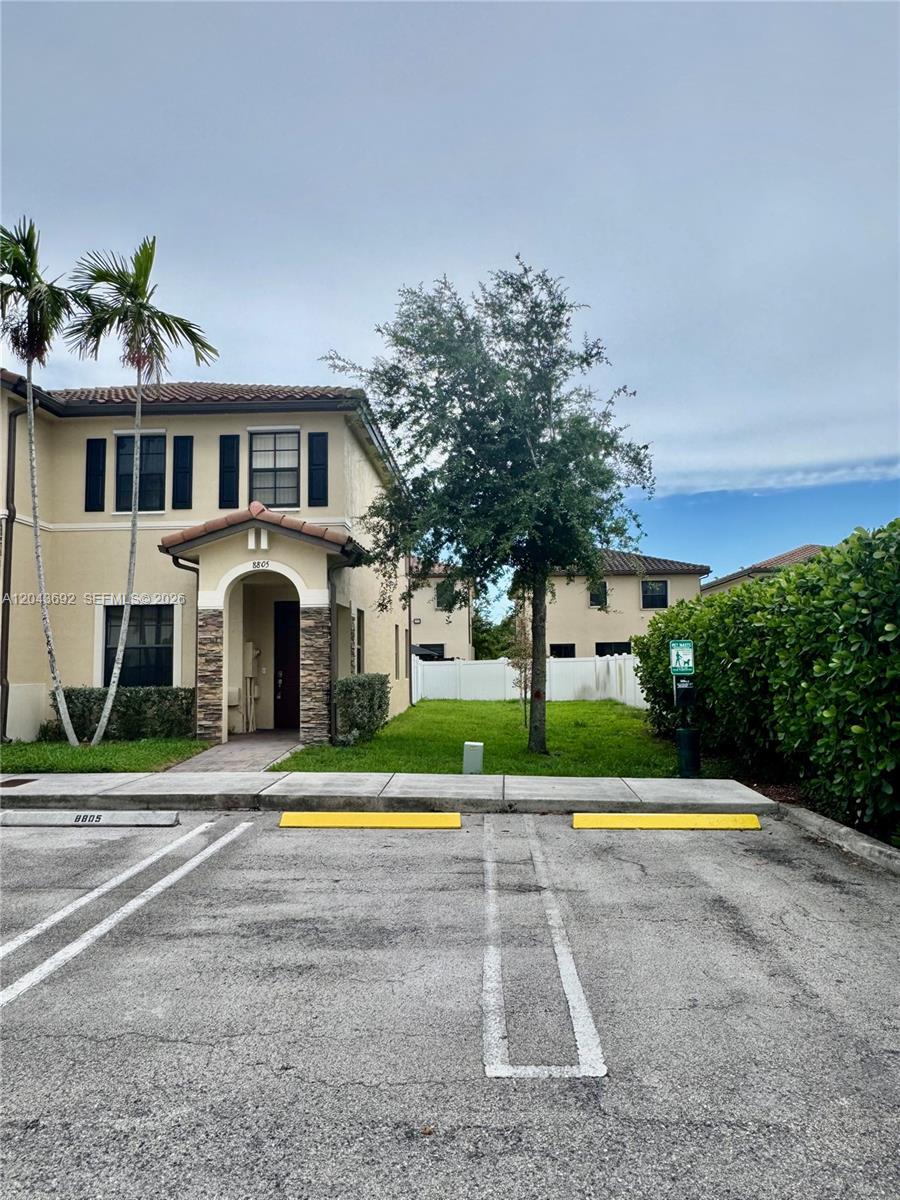 A two-story tan stucco townhouse with a stone-accented entryway and a paved parking space — 8805 W 35th Ave, Hialeah FL 33018, HIALEAH, FL