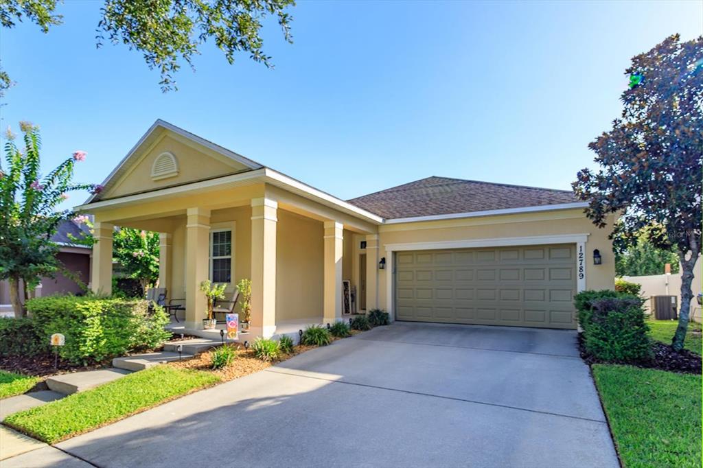 A single-story house with a yellow exterior, a front porch, and a two-car garage — 12789 BOSWORTH AVENUE, WINDERMERE, FL