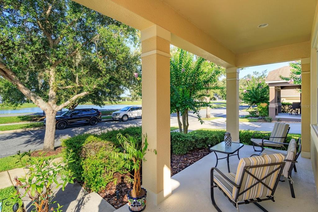 A covered front porch features two rocking chairs, a small table, and a view outdoors — 12789 BOSWORTH AVENUE, WINDERMERE, FL