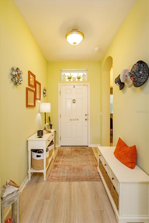An entryway features light yellow walls, a white front door, and a white storage bench — 12789 BOSWORTH AVENUE, WINDERMERE, FL