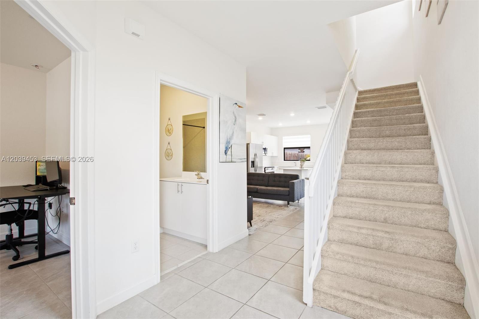 An interior view shows a tiled entryway, a carpeted staircase, a home office, and kitchen — 23391 SW 128th Ave, Homestead FL 33032, HOMESTEAD, FL