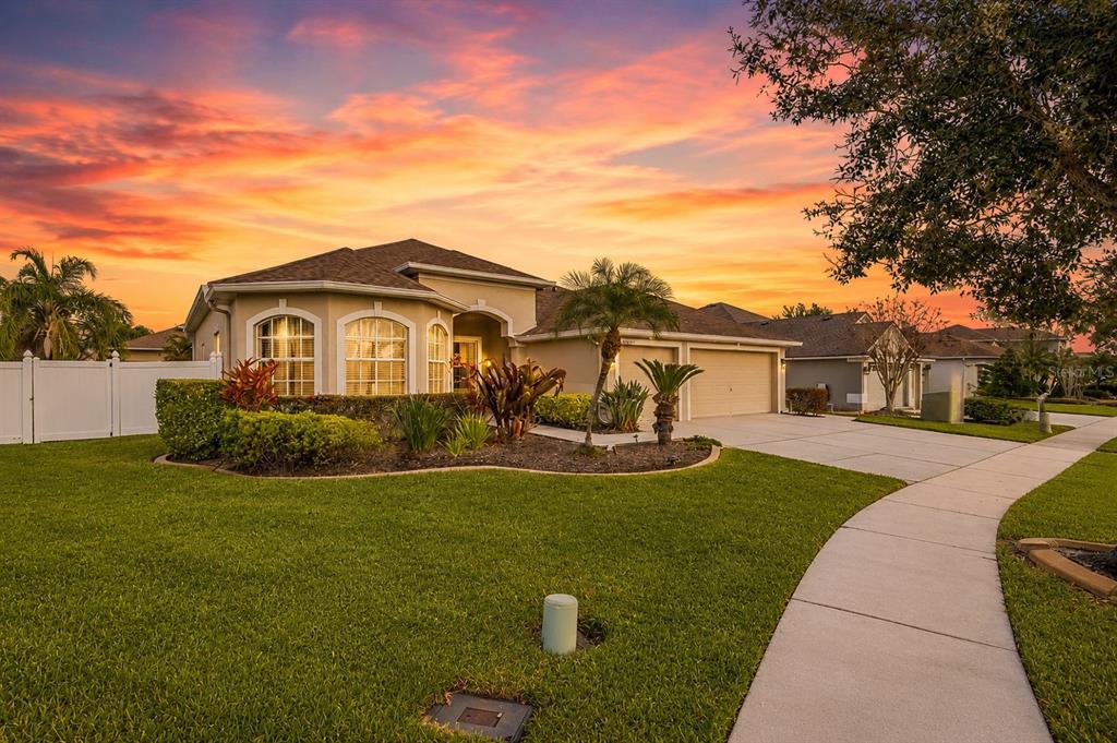 A single-story suburban house with a tan exterior, arched windows, and a two-car garage — 22623 CLIFFSIDE WAY, LAND O LAKES, FL