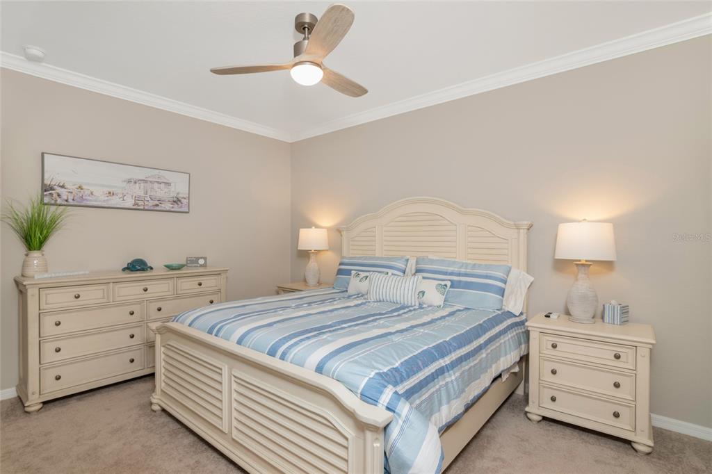 A bedroom features a light-colored bed, matching dresser and nightstands, and a ceiling fan — 14051 HERITAGE LANDING BOULEVARD UNIT 523, PUNTA GORDA, FL