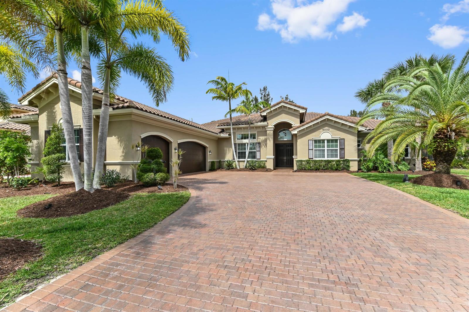 A single-story house with a brick driveway, palm trees, and a three-car garage — 7777 Eden Ridge Way, West Palm Beach FL 33412, WEST PALM BEACH, FL