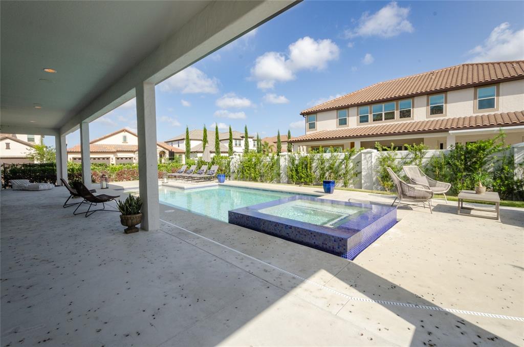 A covered patio overlooks a swimming pool with an attached tiled spa and lounge chairs — 8539 PIPPEN DRIVE, ORLANDO, FL