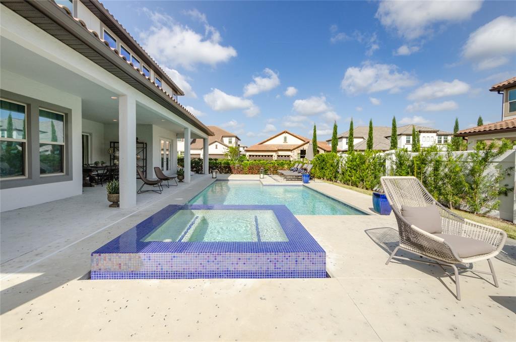 A backyard patio features a rectangular swimming pool, a tiled spa, and outdoor lounge furniture — 8539 PIPPEN DRIVE, ORLANDO, FL