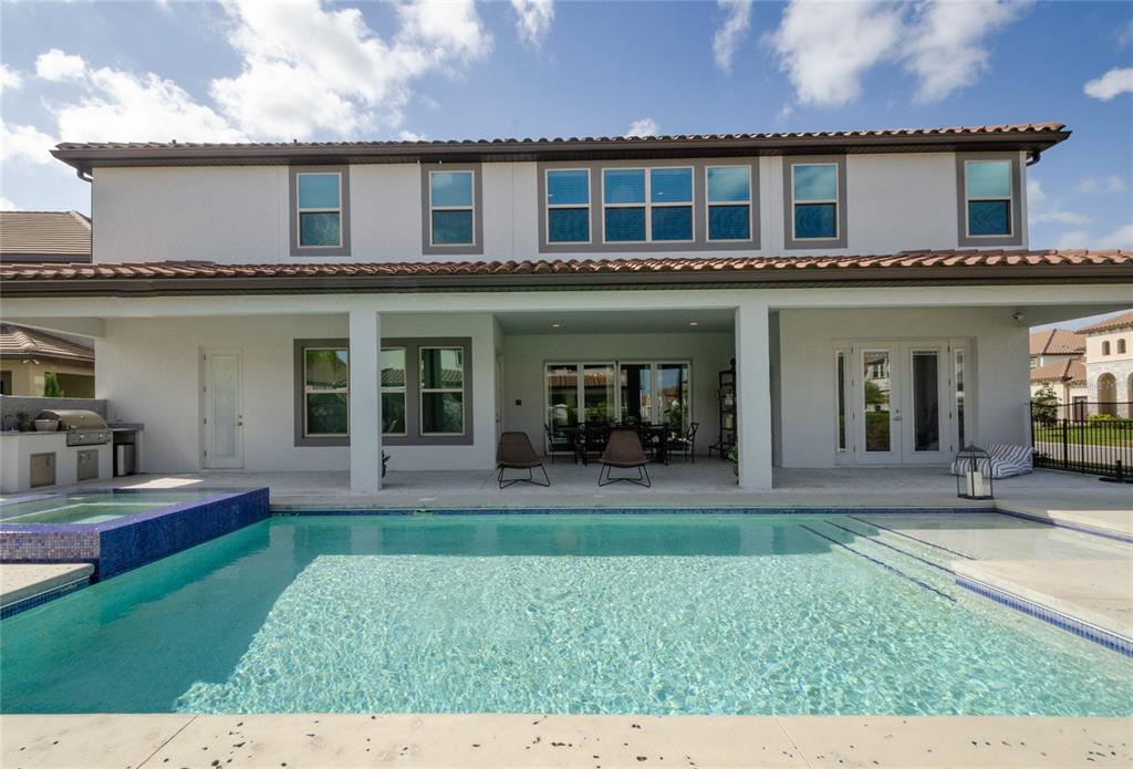 A two-story house exterior features a covered patio, a swimming pool, and a hot tub — 8539 PIPPEN DRIVE, ORLANDO, FL