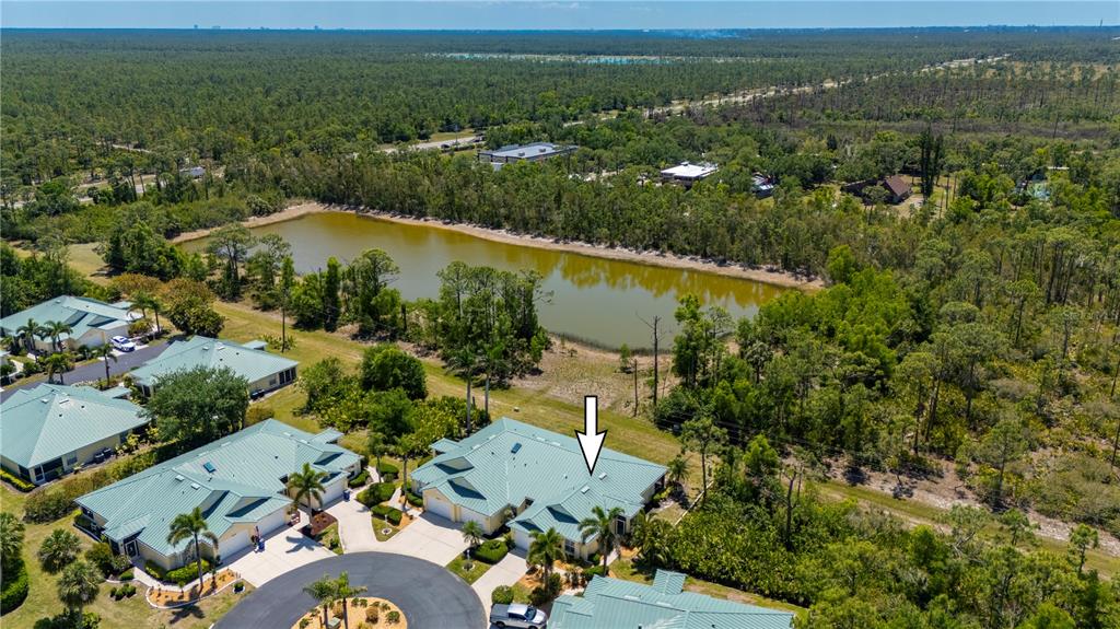 An aerial view shows a residential complex with green metal roofs near a pond — 310 ISLAMORADA BOULEVARD, PUNTA GORDA, FL