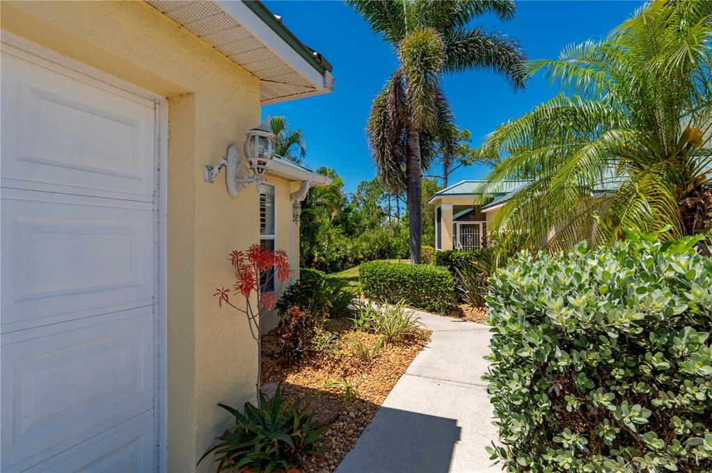 A yellow house with a teal metal roof and a white garage door — 310 ISLAMORADA BOULEVARD, PUNTA GORDA, FL