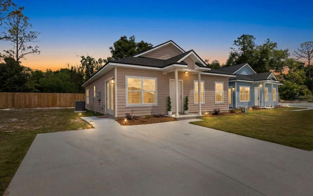 A tan, single-story house with a concrete driveway and a small covered front porch — 206 MESA STREET NW, LIVE OAK, FL