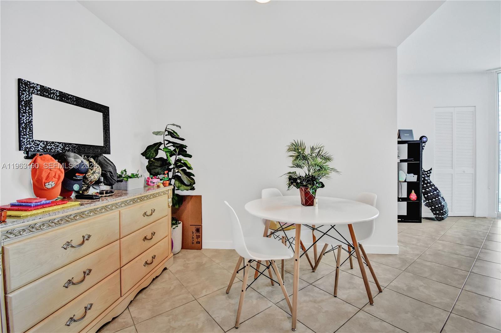 A dining area features a round white table, four chairs, and a wooden dresser — 300 S Biscayne Blvd # 1405, Miami FL 33131, MIAMI, FL