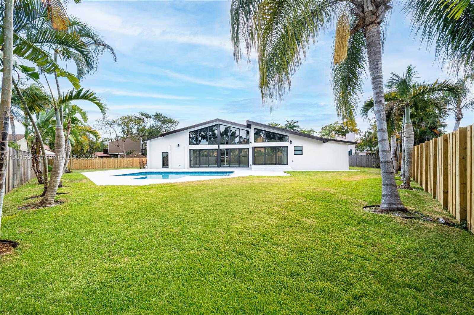 The backyard features a swimming pool, a grassy lawn, and a modern house exterior — 842 W Coco Plum Cir, Plantation FL 33324, PLANTATION, FL