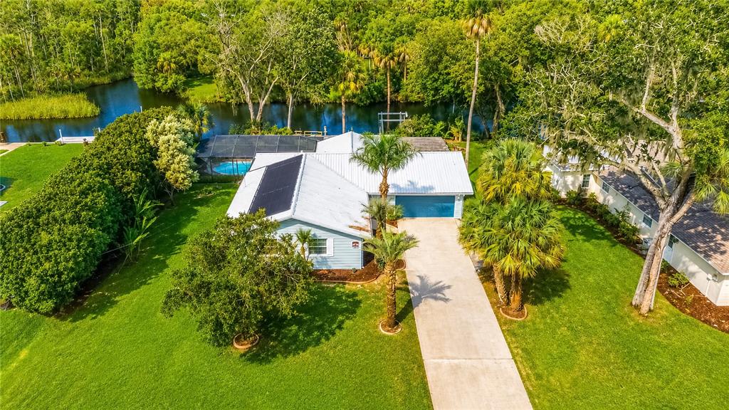 An aerial view of a light blue house with a metal roof and solar panels — 2178 N WATERSEDGE DRIVE, CRYSTAL RIVER, FL