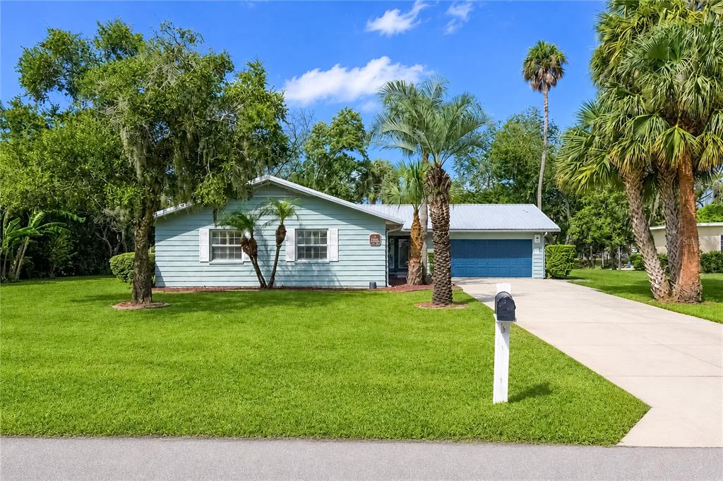 A light blue single-story house with a blue garage door and a large front lawn — 2178 N WATERSEDGE DRIVE, CRYSTAL RIVER, FL