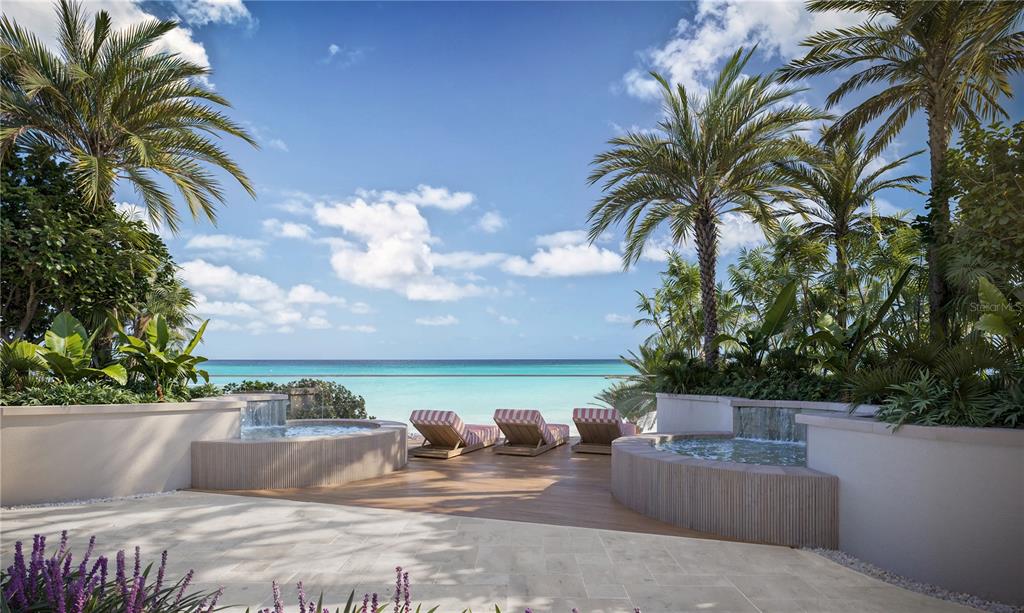 A patio features two circular hot tubs, lounge chairs, and palm trees overlooking the ocean — 805 S GULFVIEW BOULEVARD UNIT 407A, CLEARWATER BEACH, FL