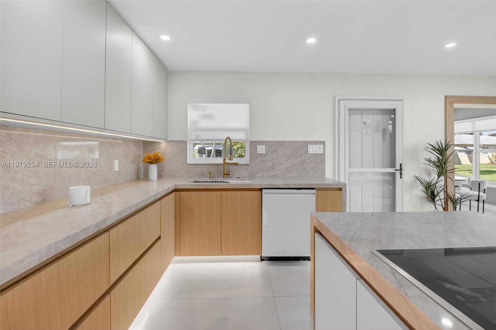 A modern kitchen features light wood cabinets, stone countertops, and a white dishwasher — 3240 Park Ln # D, Boynton Beach FL 33435, BOYNTON BEACH, FL