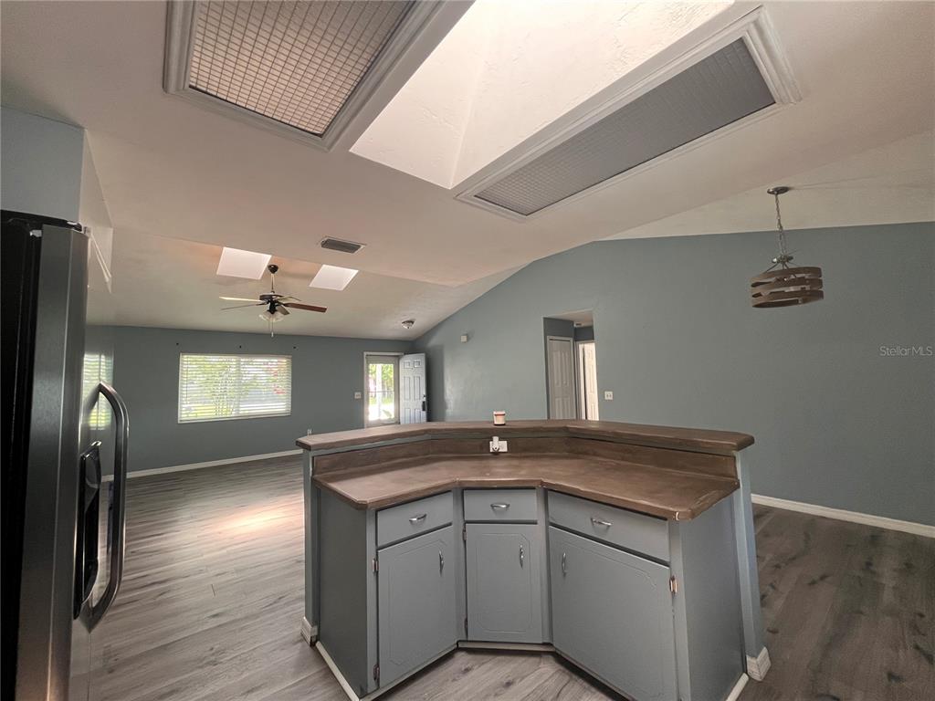 A kitchen island with a wood countertop sits in a room with gray walls — 2511 MILTON AVENUE, NEW SMYRNA BEACH, FL