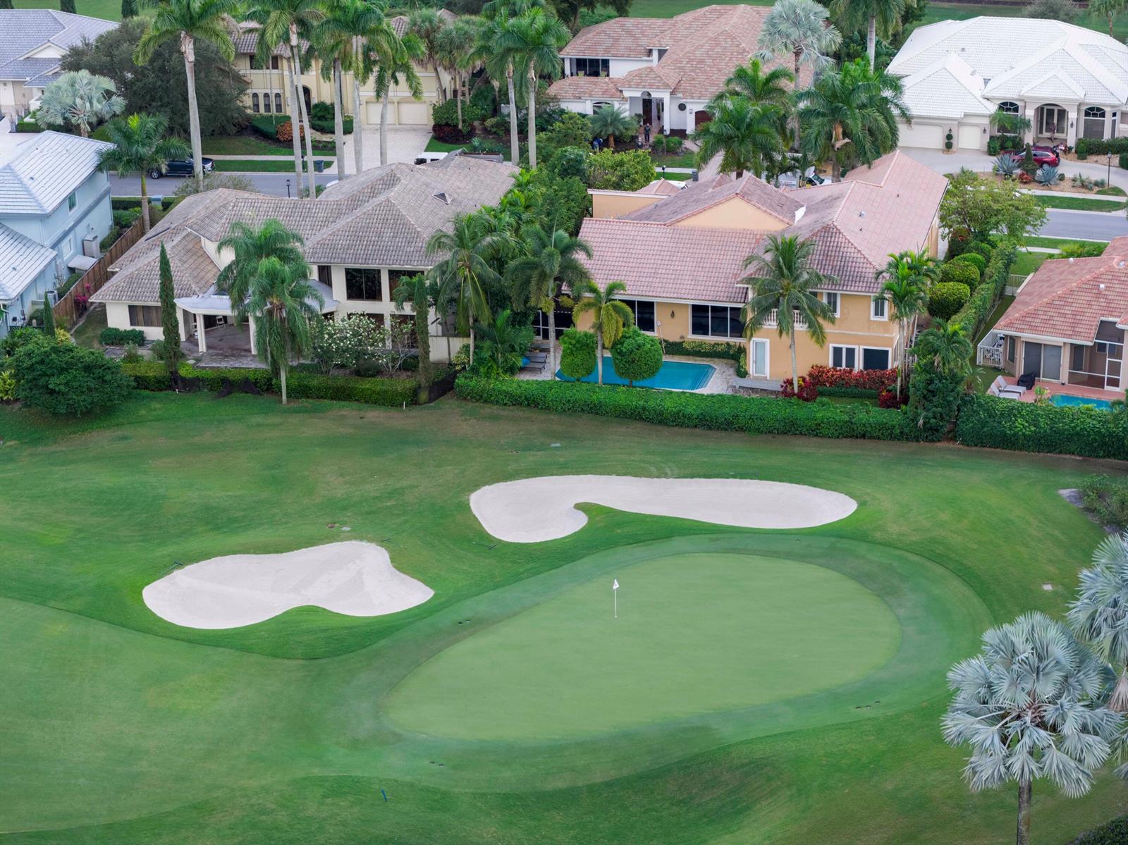 An aerial view of a golf course green with sand bunkers behind several residential homes — 7355 Mandarin Drive, Boca Raton FL 33433, BOCA RATON, FL