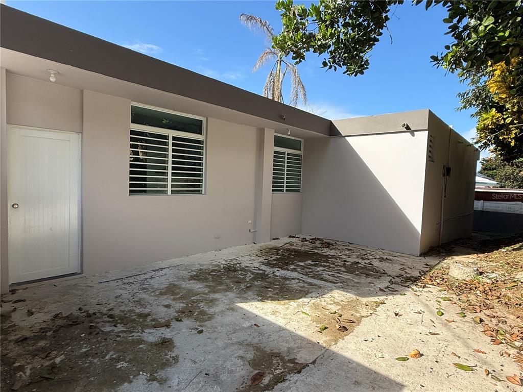 A concrete patio area sits adjacent to the exterior wall of a light-colored house — 21 Andes MONTEREY, SAN JUAN, PR