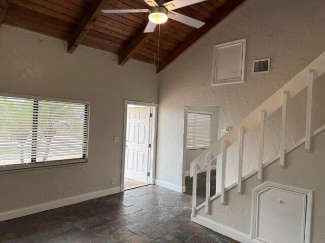 A living room features a vaulted wood-beam ceiling, tile flooring, and a white staircase — 103 NE 28th Street, Boca Raton FL 33431, BOCA RATON, FL