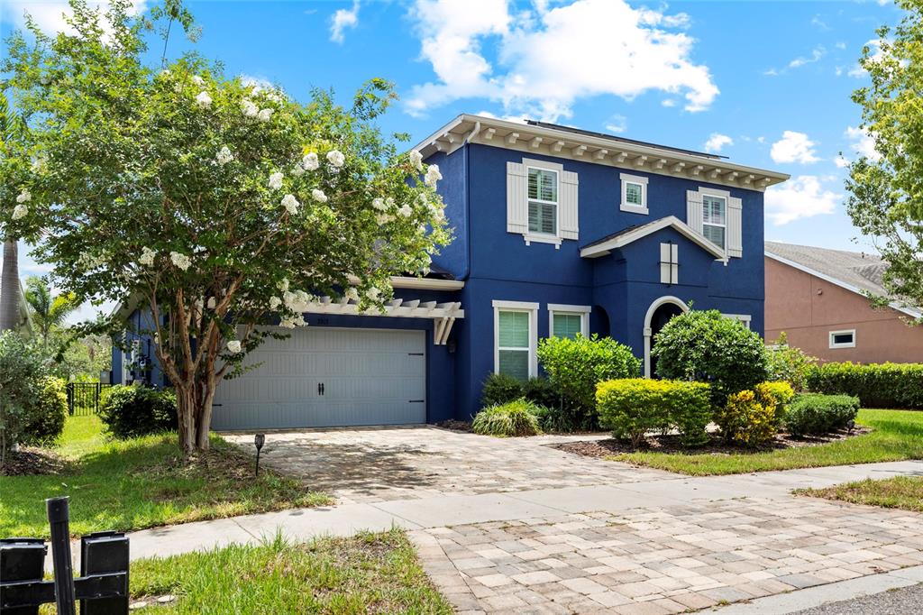 A two-story blue house with a gray garage door and a paved driveway — 7013 ARTESIAN COURT, APOLLO BEACH, FL