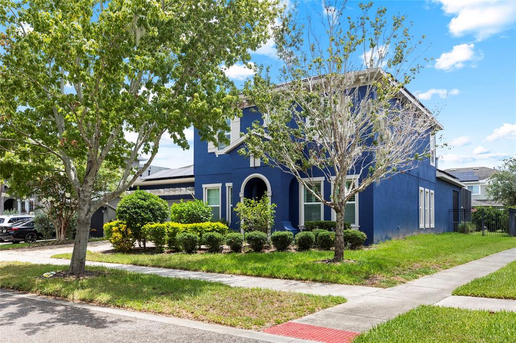 A two-story blue house with a front yard, trees, and a driveway — 7013 ARTESIAN COURT, APOLLO BEACH, FL