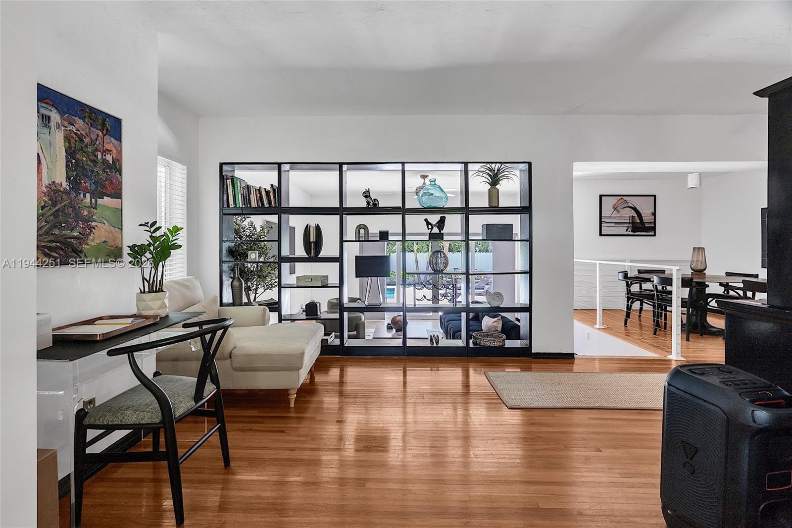 A living room features hardwood floors, a black room divider, and a desk area — 660 NE 121st St, Biscayne Park FL 33161, BISCAYNE PARK, FL