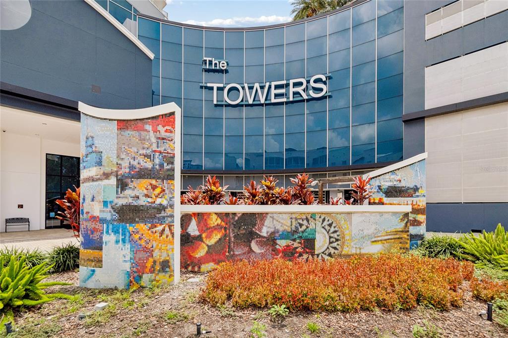 The exterior of a modern building features a curved glass facade and decorative mosaic walls — 449 S 12TH STREET UNIT 802, TAMPA, FL