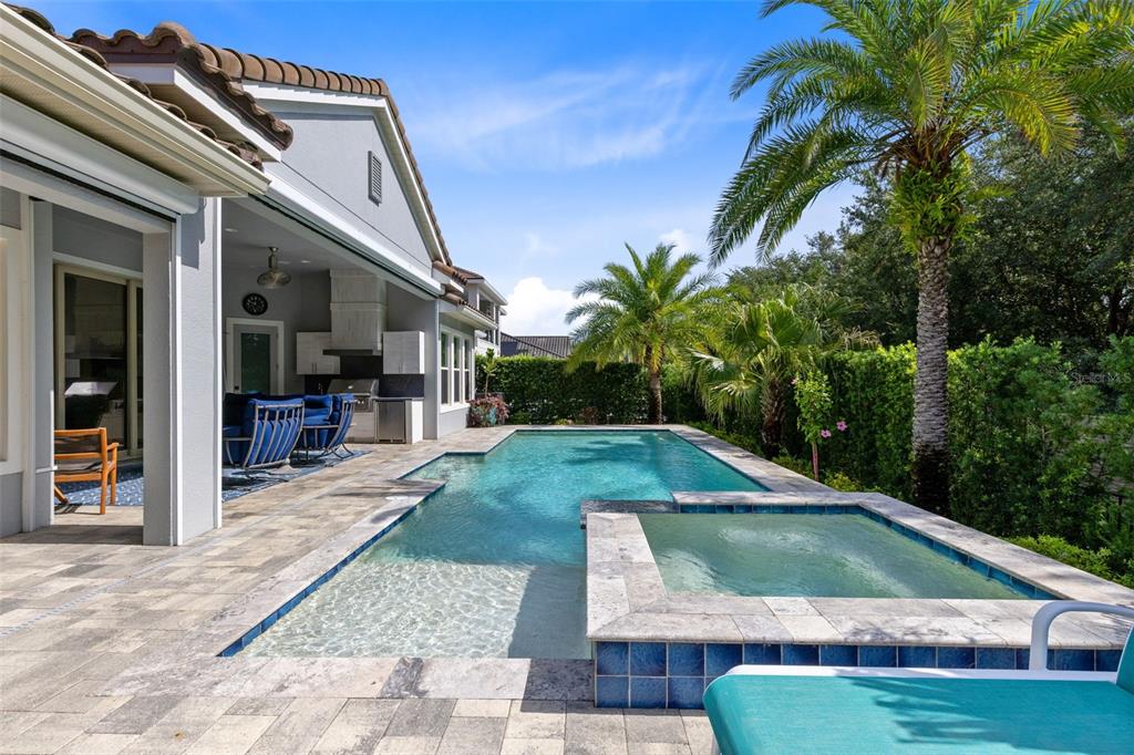 A backyard features a swimming pool, a raised spa, and a covered patio with furniture — 3895 GRASSLAND LOOP, LAKE MARY, FL