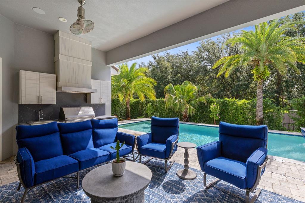 An outdoor patio features a blue sofa and armchairs, a grill station, and a swimming pool — 3895 GRASSLAND LOOP, LAKE MARY, FL